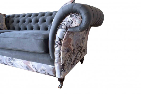 Un canapé trois places remarquable de style Chesterfield avec une délicate décoration florale grise.