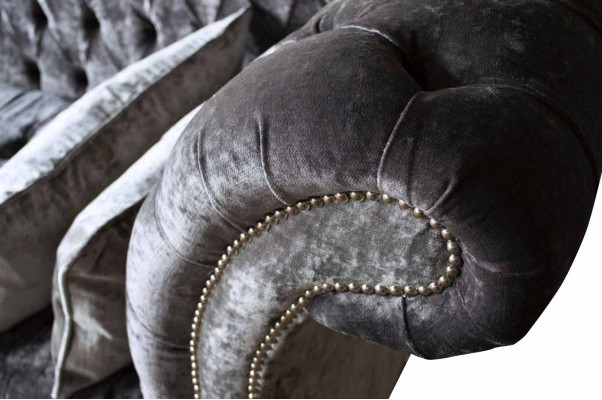 Un luxueux canapé de style Chesterfield classique dans une riche tonalité argentée.