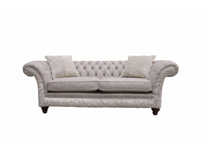 Moderne canapé design trois places en tissu d'ameublement beige Chesterfield pour le salon.