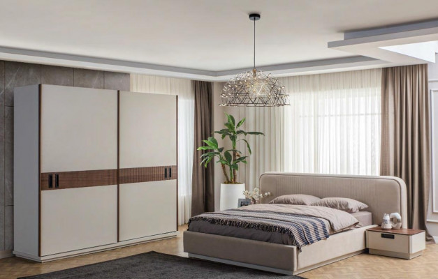 Grand lit double en textile beige avec armoire en bois et tables de chevet modernes.