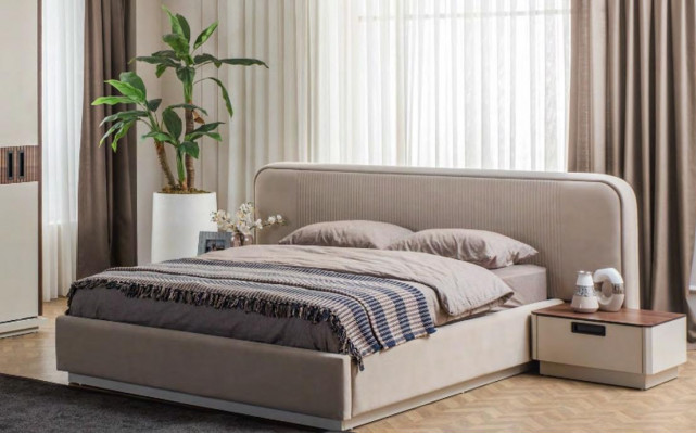 Grand lit double en textile beige avec armoire en bois et tables de chevet modernes.