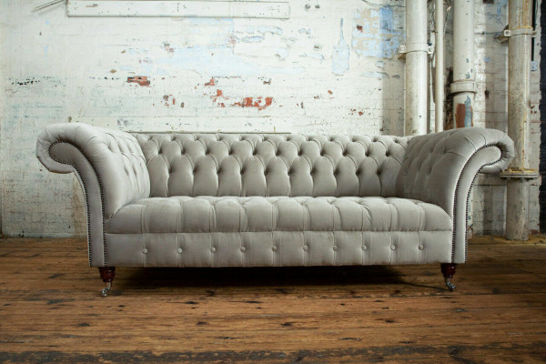 Élégant canapé Chesterfield gris clair trois places de luxe pour le salon.