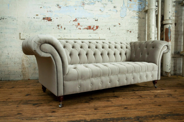 Élégant canapé Chesterfield gris clair trois places de luxe pour le salon.