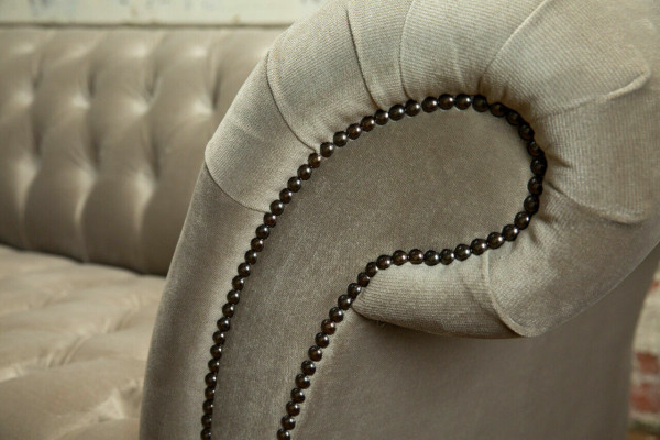 Élégant canapé Chesterfield gris clair trois places de luxe pour le salon.