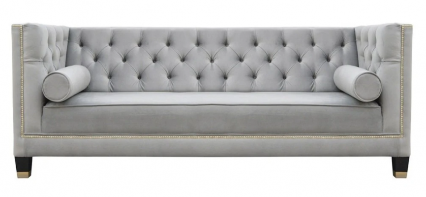Un luxueux canapé Chesterfield en velours gris trois places pour l'ameublement de la salle de séjour de l'hôtel.
