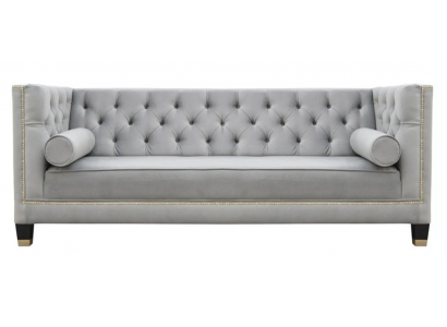 Un luxueux canapé Chesterfield en velours gris trois places pour l'ameublement de la salle de séjour de l'hôtel.