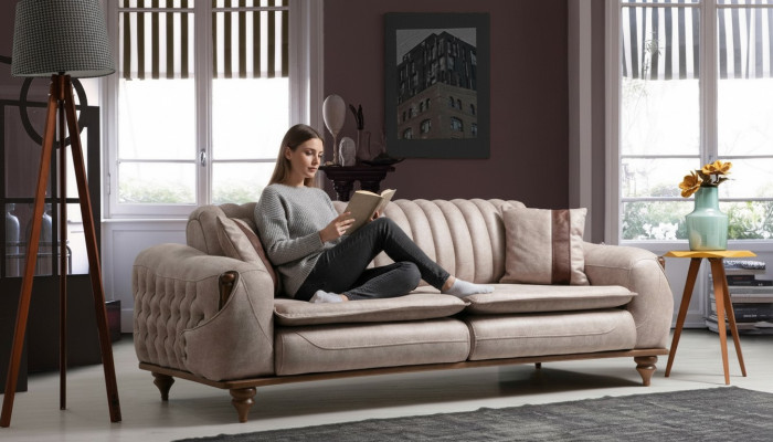 Canapé Chesterfield trois places beige en tissu d'ameublement.