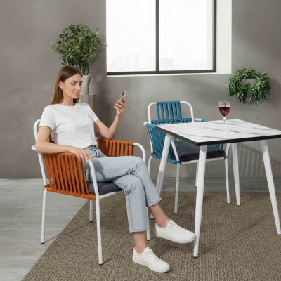 Chaise de couleur claire originale sur des pieds en acier inoxydable blanc et un coussin de siège moelleux