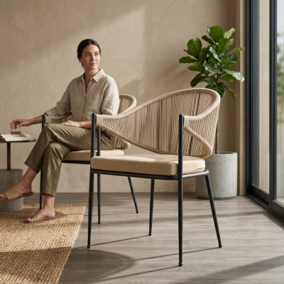 Chaise beige à un seul siège en tissu pour la salle à manger avec des éléments en acier inoxydable.