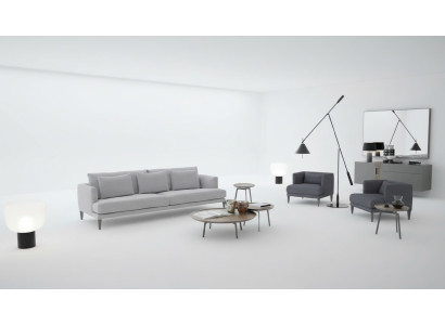 Grand salon composé d'un canapé trois places, d'un fauteuil, de tables basses et de meubles en bois gris.