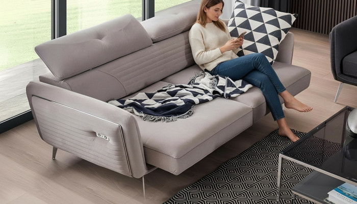 Luxueux, canapé deux places à la mode avec un revêtement textile sur des pieds hauts.