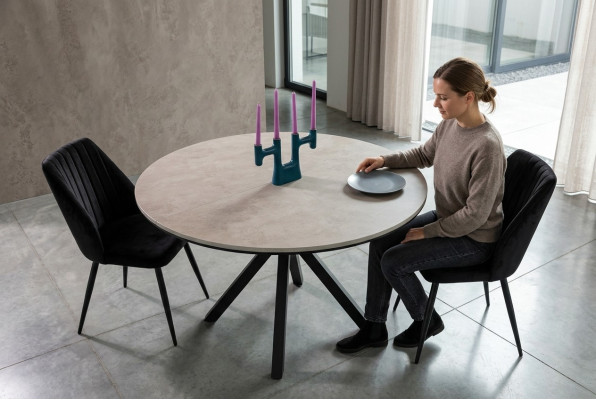 Table ronde extensible en bois gris pour salle à manger.