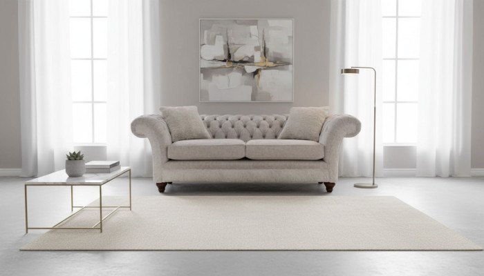 Moderne canapé design trois places en tissu d'ameublement beige Chesterfield pour le salon.