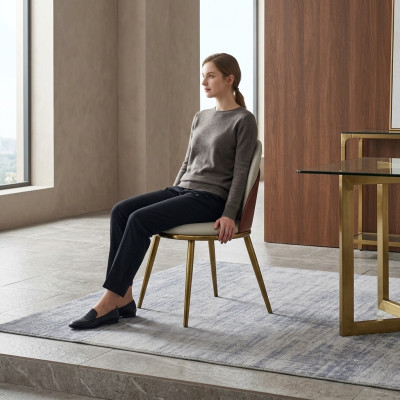 Chaise ornée élégante en acier inoxydable, un siège blanc-doré.