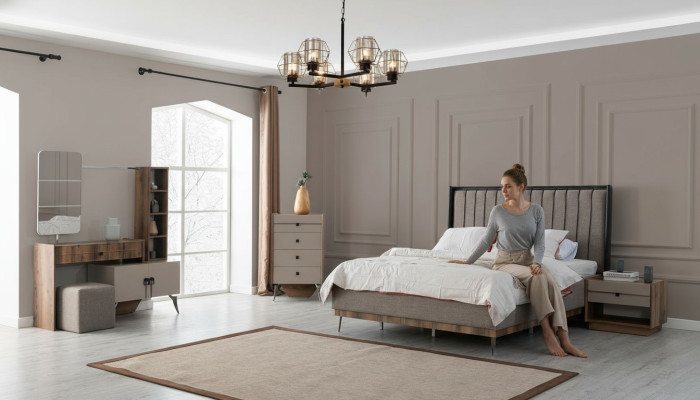 Suite de chambre grise avec lit double, 2 tables de chevet en bois et une coiffeuse.