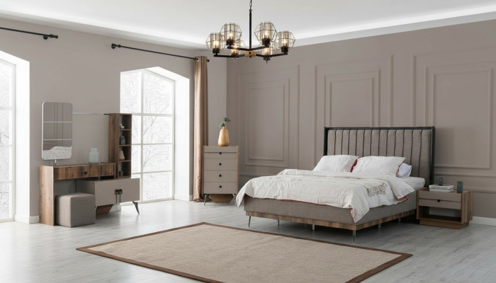 Suite de chambre grise avec lit double, 2 tables de chevet en bois et une coiffeuse.